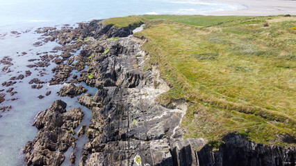 Rocky coast of the Atlantic Ocean in Ireland, top view. Rocky coast, seaside landscape. Irish nature. Green grass field on gray rocky mountain