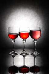 Still life with three glasses of red liquid