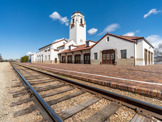 Blue sky and clouds of an iconic train depot with tracks