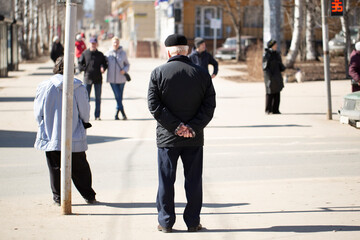 Obraz premium An elderly man in the city.A pensioner travels around the city in the spring.