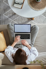 Mockup white screen laptop woman using computer sitting on sofa at home, top view