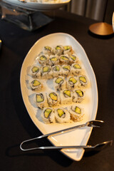 platter of vegetarian avocado sushi rolls on large white oval platter at event