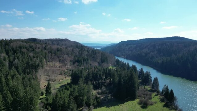 Luftaufnahme Lech mit bewaldeten H&auml;ngen und Blick auf die Alpen