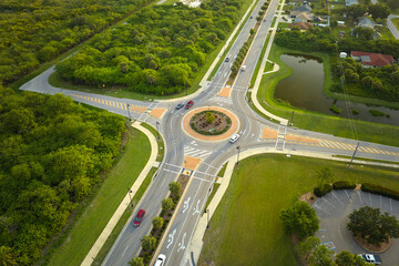 Aerial view of road roundabout intersection with moving cars traffic. Rural circular transportation crossroads - obrazy, fototapety, plakaty