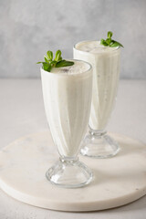 Indian Salty lassi with mint leaves and kala namak on white background. Vertical format. Traditional healthy freshness lassi made of yogurt, water, spices and ice.