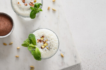 Indian Salty lassi with mint leaves and kala namak on white background. Traditional healthy...