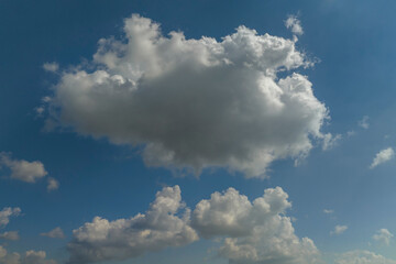 Bright landscape of white puffy cumulus clouds on blue clear sky