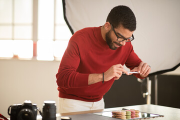 Man photographing delicious tasty sweet dessert macaroons, copy space
