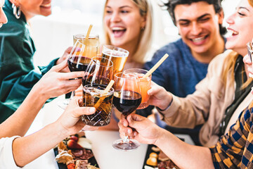 Group of friends toasting fancy cocktails together sitting at bar restaurant table-Happy young people celebrating party enjoying happy hour with wine and beer-Food and beverage lifestyle concept - obrazy, fototapety, plakaty