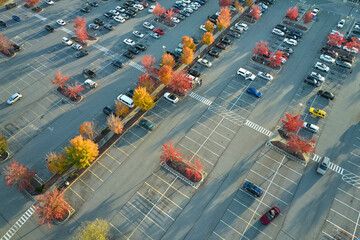 View from above of many parked cars on parking lot with lines and markings for parking places and...