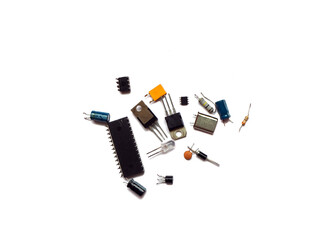 Various electronic circuit components on a white. Semiconductors, resistors, capacitors, integrated circuits.