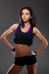 A beautiful young sports girl on a gray background, beautiful abdominal muscles, a beautiful figure. - 593340055
