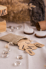 Handmade cardboard Scandinavian runes in a bag on a divination table vertical view