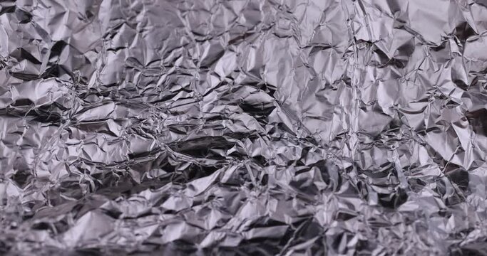 move old used crumpled aluminum foil, close-up of a foil structure with crumbs from food