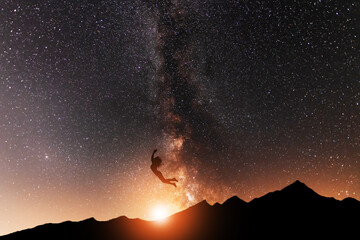 Fantasy landscape, girl silhouette jumping, on the milky way galaxy background. Night landscape.