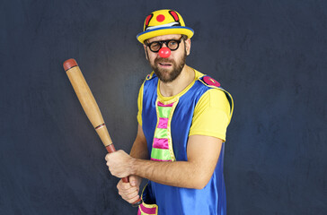 An insecure clown holds a bat in his hands