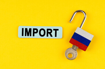 On the yellow surface is an open lock with a key and a sticker with the inscription - import