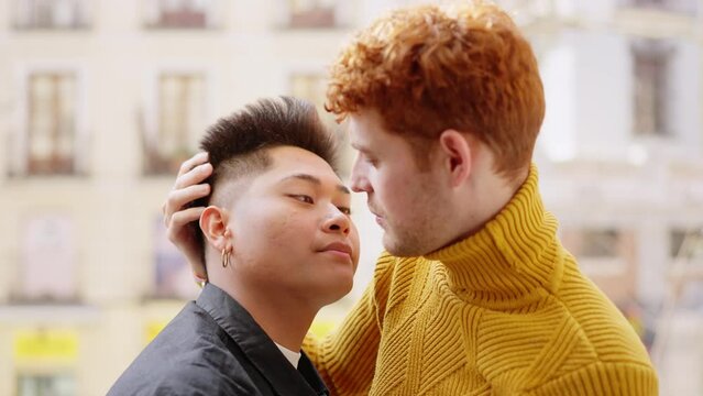 Gay couple about to kiss on the balcony