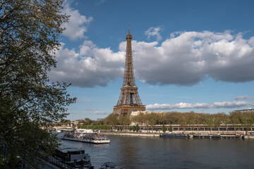 Fototapeta na wymiar Eiffel tower with a barge passing by on a sunny day