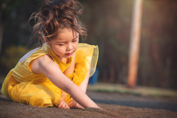 beautiful junior little girl playing in the park in yellow dress laughing with bubbles, screaming...