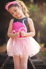 beautiful minor little girl playing in the park with ballerina costume laughing screaming with...