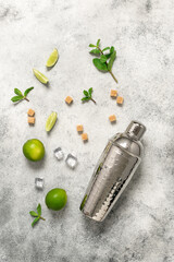 Mojito ingredients. Shaker, lime, mint leaves, cane sugar and ice cubes on a light vintage background. Top view, flat lay, copy space., vertical