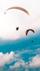 Two paragliders flying in the sky