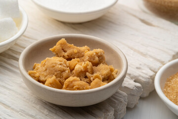 Natural Coconut palm sugar in white dish.Sweet condiment for Thai Traditional food.