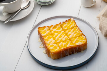 Air fryer grilled butter toast,golden brown crispy bread topped with sugar and sweetened condensed milk on white plate