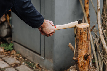 Strong man, lumberjack, worker chops firewood, logs, trees with an ax in the forest, outdoors, nature. Photography, portrait.