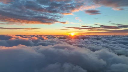 Epic sunset over the clouds. Flight in the sky at sunset, view from window of airplane. Warm sun sets over the horizon in clouds © SJ Travel Footage