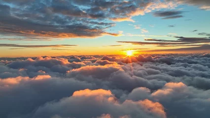 Selbstklebende Fototapete Landschaft Sun goes into the clouds. Epic sunset in the sky, aerial shot. Flying above the clouds illuminated by the evening sun