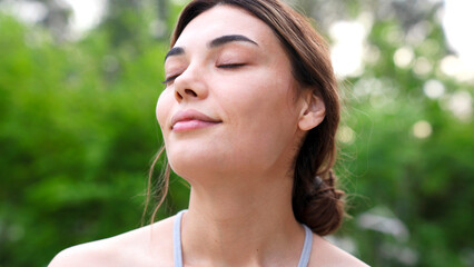Relaxed young woman meditating outdoors