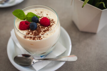 Italian dessert Tiramisu with berries and cocoa