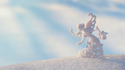 Christmas winter background - view of an Christmas angel in a winter forest, sparkling in the rays...