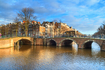 Cityscape on a sunny winter day - view of the bridges and canals in the historic center of Amsterdam, The Netherlands