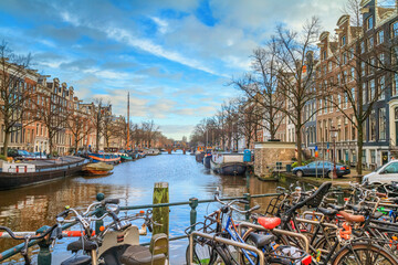 Cityscape on a sunny winter day - view of the water canal from the bridge in the historic center of Amsterdam, the Netherlands