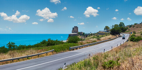 Picturesque historical fortification tower between regional road and beach on Ionian sea coast, South Italy