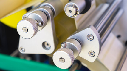 Fragment of the conveyor of sticking labeling machine. Abstract industrial background.