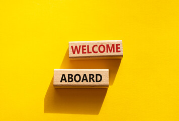 Welcome aboard symbol. Concept word Welcome aboard on wooden blocks. Beautiful yellow background. Business and Welcome aboard concept. Copy space