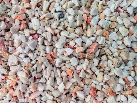 Light decorative stones for the garden in shades of beige, pink and brown. Stone background.