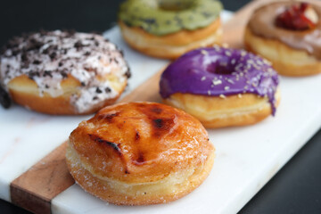 Assorted gourmet and colorful donuts served on a board