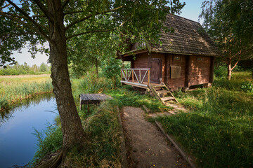 Fototapeta na wymiar Bath house on the shore of the pond in summer.