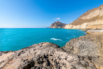 The rocky coastline and hills near Mughsail Beach, along the Arabian Sea near Salalah, Oman.
