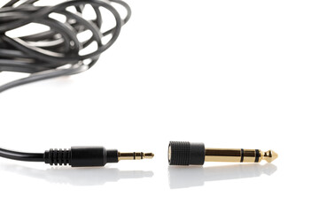 Aux to mini jack adapter. Adapter 3.5 mm to 6.5 mm aux audio jack on a white background. Close-up.