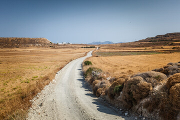 Rural narrow dirt road somewhere on Milos island, Greece - 593380401