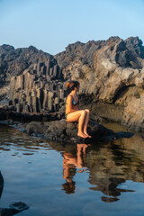 Fototapeta premium Sunset on El Hierro Island. Canary Islands, a tourist woman bathing in the natural pool of Charco Azul