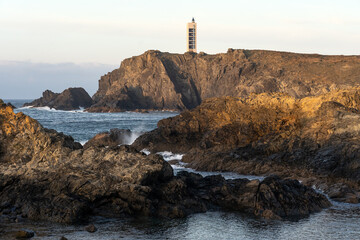 Punta Frouxeira lighthouse with the cliffs in the Rias Altas touristic area of Galicia at sunset, Valdoviño, Meiras, Spain.