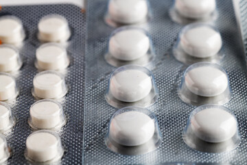 tablets and capsules pill in blister packaging arranged close-up.