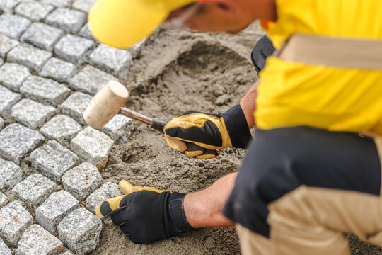 Professional Construction Worker Laying Pavers